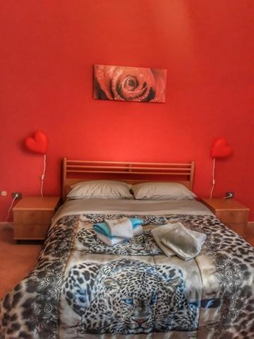 a bedroom with a cheetah bed with a red wall at Antica Conca D'oro in Ogliastro Cilento