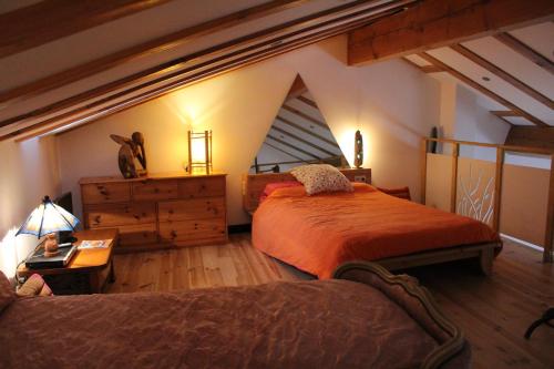 an attic bedroom with two beds and a dresser at maison de la salamandre in Ribes