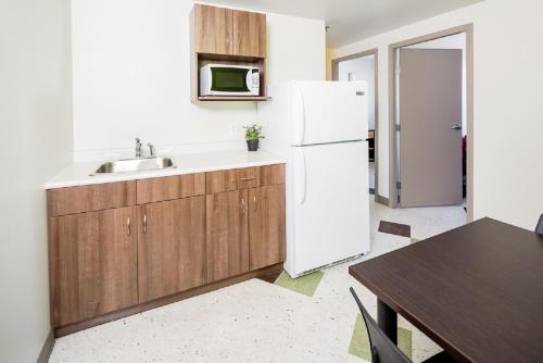 a kitchen with a sink and a white refrigerator at UWinnipeg Downtown Hostel in Winnipeg