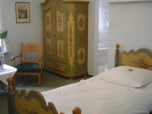 a bedroom with a bed and a large dresser at Hotel Alte Post in Wangen im Allgäu