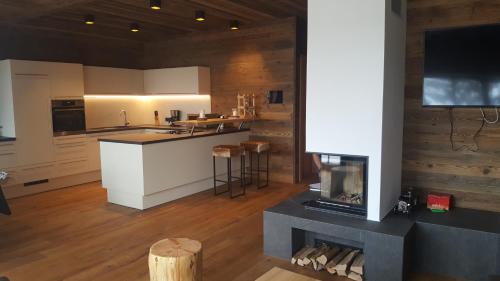 a kitchen with a stove and a fireplace at Wildererhütte Chalet Helmut in Turracher Hohe
