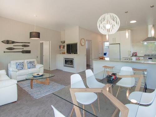a living room and kitchen with a table and chairs at Flaxmill Accommodation in Whitianga