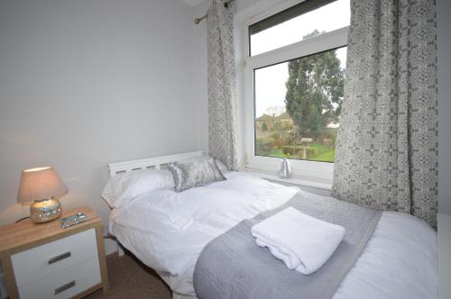 um quarto com uma cama branca e uma janela em Whole House - Sleeps 5 - near town centre - off road parking em Hinckley