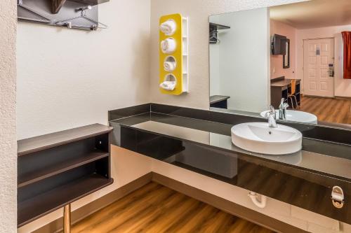 een badkamer met een wastafel en een spiegel bij Motel 6-Arlington, TX - UTA in Arlington