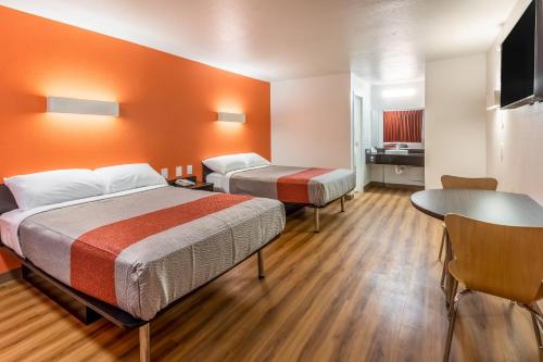 Motel 6-Arlington, TX - UTA في أرلينغتون: غرفة فندقية بسريرين وطاولة