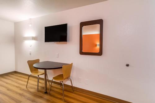 a dining room with a table and chairs and a mirror at Motel 6-Arlington, TX - UTA in Arlington
