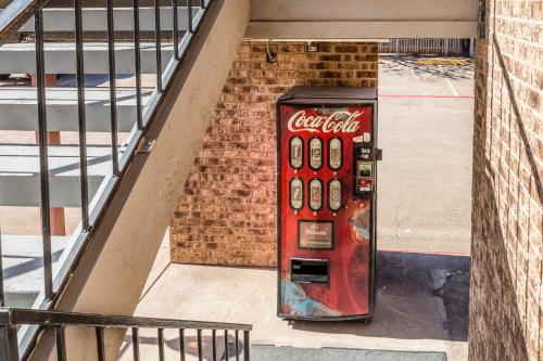 an old cocacola soda machine sitting next to a building at Motel 6-Arlington, TX - UTA in Arlington