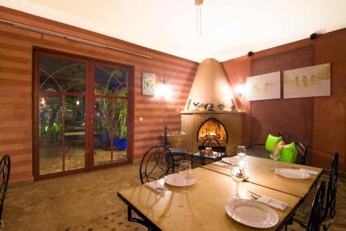a dining room with a table and a fireplace at Le Relais De Marrakech in Marrakech