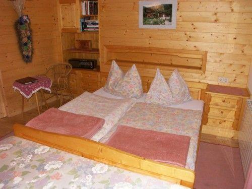 a bedroom with a bed in a wooden room at Ferien-am-Bauernhof-Wohnung-2 in Rangersdorf