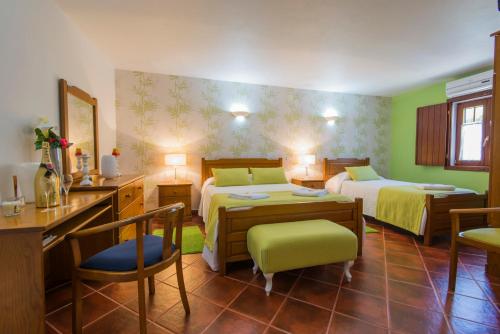 a bedroom with two beds and a desk and chairs at Herdade do Sardanito da Frente in Zambujeira do Mar