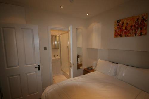 1 dormitorio con cama blanca y baño en 69TheGrove, en Londres