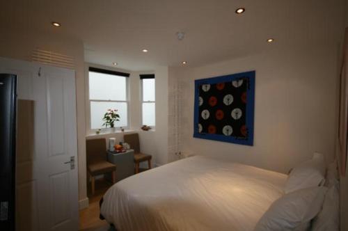 1 dormitorio con 1 cama y una pintura en la pared en 69TheGrove, en Londres