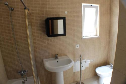 een badkamer met een wastafel, een douche en een toilet bij T0 Portimão - Center in Portimão