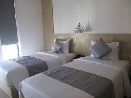 a hotel room with two beds and a pendant at Khách Sạn Hiệp Yến in Tuy Hoa