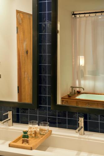 a bathroom with a sink with a mirror and a tub at Hotel El Ganzo - Adults Only in San José del Cabo