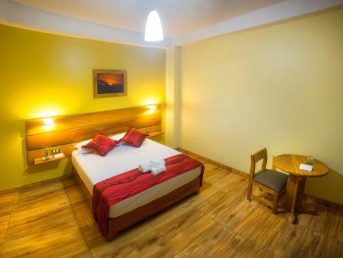 a bedroom with a bed and a table and a chair at Copasu Hotel in Puerto Maldonado