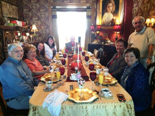 a group of people sitting around a long table at Alexander Mansion Bed & Breakfast in Winona