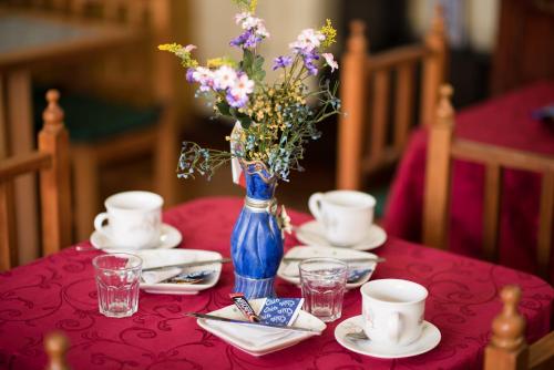 a red table with a blue vase with flowers in it at Si Hotel in Santiago