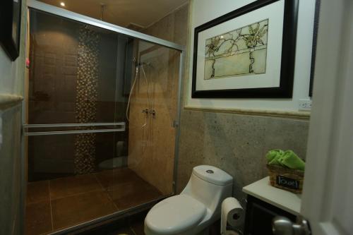 a bathroom with a shower and a toilet with a glass door at Trojan House in Ensenada