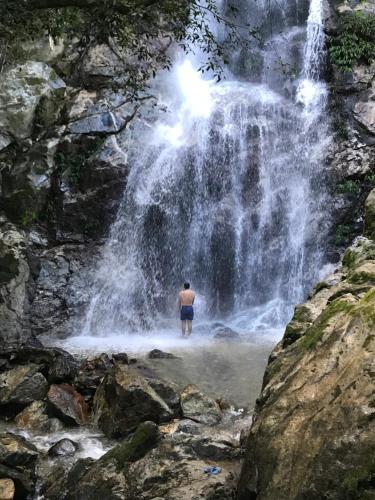 a man standing in front of a waterfall at Reserva Natural Tierra Adentro in Minca