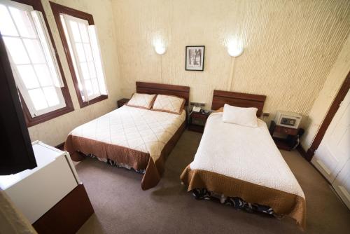 um quarto com 2 camas e 2 janelas em Si Hotel em Santiago