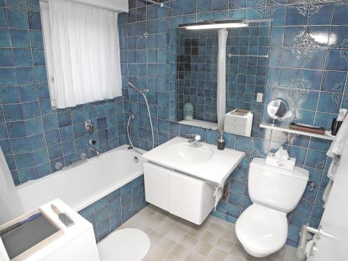 MinusioにあるCasa Fontanalba App 1111の青いタイル張りのバスルーム(トイレ、シンク付)