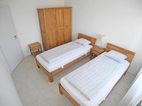 MinusioにあるCasa Fontanalba App 1111のベッドルーム1室(ベッド2台、木製キャビネット付)