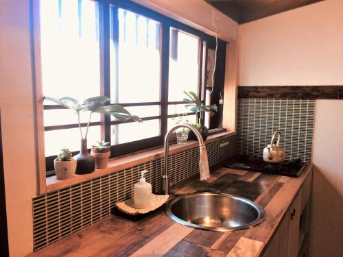 encimera de cocina con fregadero y ventana en Guest House Kobako, en Kioto