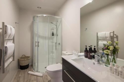 a bathroom with a shower and a toilet and a sink at Lakefront Luxury by Amazing Accom in Queenstown