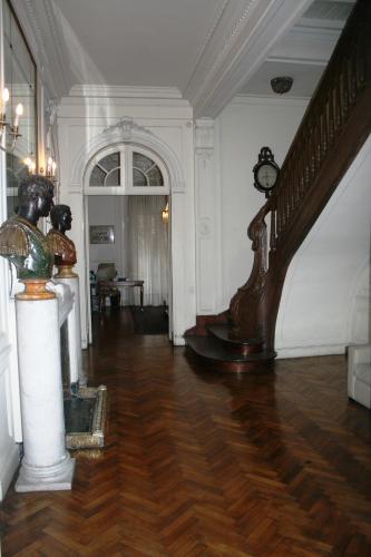 un corridoio con scala e orologio in un edificio di Leonardo Da Vinci Residence a Buenos Aires