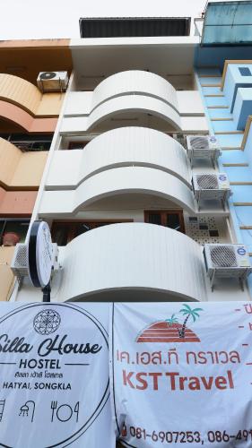 a building with a sign in front of it at Silla House in Hat Yai