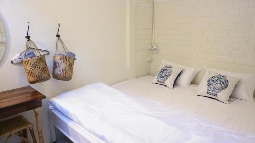 a bedroom with a white bed with pillows on it at Silla House in Hat Yai