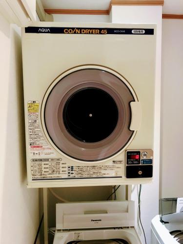 a microwave oven sitting on top of a wall at Guesthouse LuLuLu 無料朝食&夕食ｶﾚｰ 街まで電車8分 ﾛｰｿﾝ隣 in Kochi