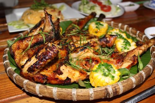 a plate of food with chicken and other foods on a table at Happy Farm Tien Giang Homestay in My Tho