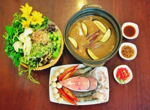 a table with a bowl of soup and a plate of food at Happy Farm Tien Giang Homestay in My Tho
