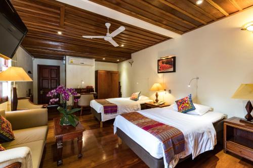 a hotel room with two beds and a couch at Mekong Riverview Hotel in Luang Prabang
