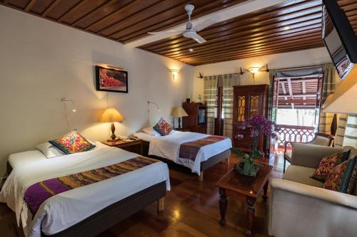a hotel room with two beds and a couch at Mekong Riverview Hotel in Luang Prabang