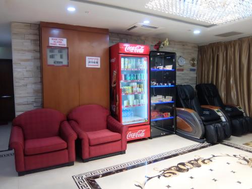 sklep z coca cola z dwoma krzesłami i automatem do napojów w obiekcie YaJu Hotel w Singapurze