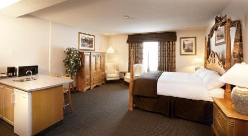 Petawawa River Inn & Suites في Petawawa: غرفة فندق فيها سرير ومغسلة