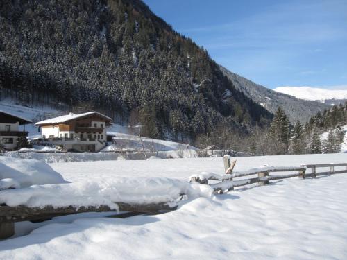 a fence covered in snow in front of a mountain at Alpenapart Walch in Jerzens
