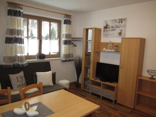 a living room with a television and a table at Alpenapart Walch in Jerzens