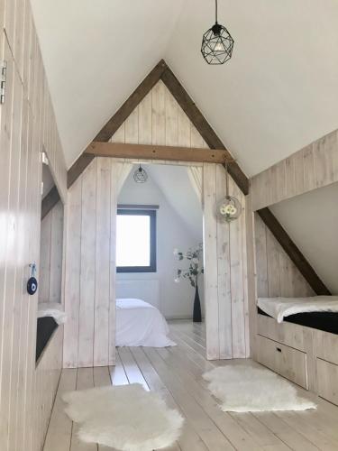 an attic bedroom with a bed and a window at Dream house in Poperinge