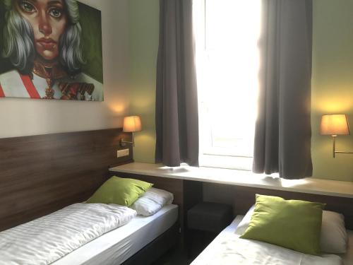 a room with two beds and a painting of a woman at Urban Stay Salzburg City in Salzburg