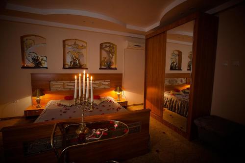 a room with a mirror and a bed with candles at Hotel Roco in Izvin