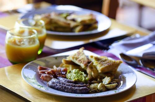 two plates of food with sausage and toast on a table at Hartbeespoortdam Lodge in Hartbeespoort