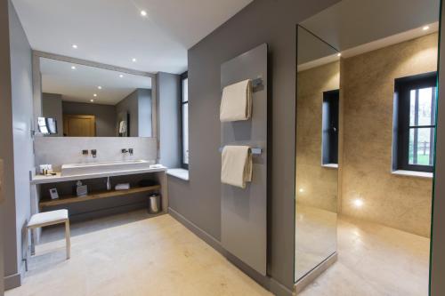 a bathroom with a sink and a mirror at Domaine de Rymska & Spa - Relais & Châteaux in Saint-Jean-de-Trézy
