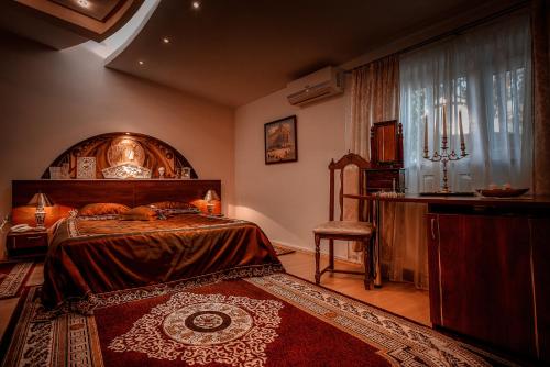 a bedroom with a bed and a table and a chair at Hotel Roco in Izvin