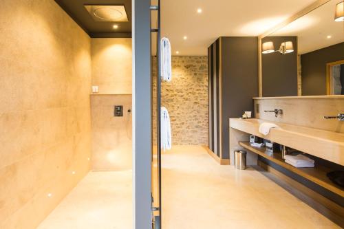 a bathroom with a sink and a mirror at Domaine de Rymska & Spa - Relais & Châteaux in Saint-Jean-de-Trézy