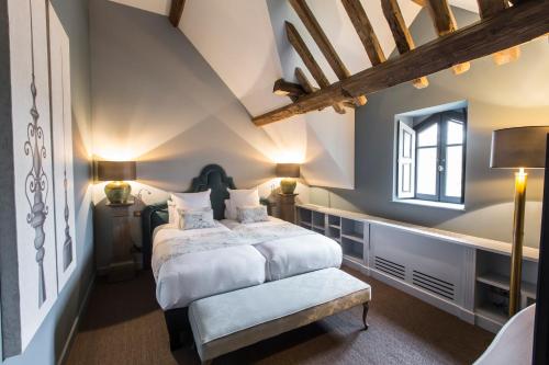 a bedroom with a king sized bed and a window at Domaine de Rymska & Spa - Relais & Châteaux in Saint-Jean-de-Trézy