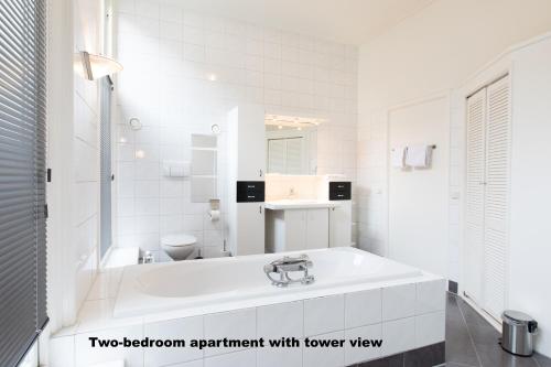 a white bathroom with a sink and a toilet at Hotel de Vischpoorte, centrum Deventer en aan de IJssel in Deventer